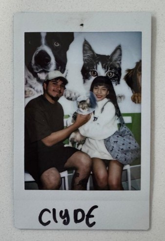 couple holding cat polaroid