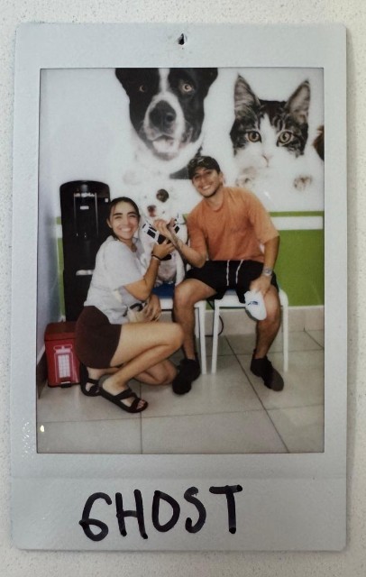 two people holding small dog